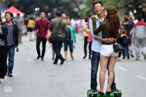 Ảnh nam nữ ôm nhau trượt xe điện thăng bằng bất chấp nguy hiểm