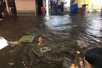 Du khách nước ngoài “chill” trong nước mưa ngập phố cổ