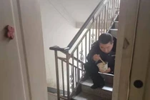 Sợ lây bệnh cho vợ con, cảnh sát ngồi ăn ở cầu thang, nhét bát qua khe cửa khiến bao người xót xa