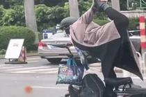 Tập yoga khi phóng xe, bác gái khiến người đi đường khiếp sợ 