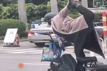 Tập yoga khi phóng xe, bác gái khiến người đi đường khiếp sợ 