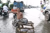 Cởi trần giữa phố ngập nước điều tiết giao thông