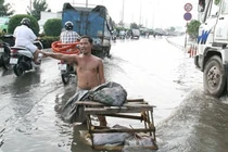Cởi trần giữa phố ngập nước điều tiết giao thông