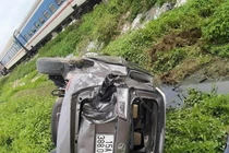 Cố vượt đường tàu, xe Innova ngửa bụng nằm dưới ruộng