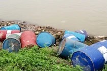 Hàng chục thùng phuy lạ rò rỉ chất đen xì mùi nồng nặc đổ xuống sông Hồng