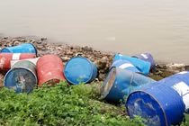 Hàng chục thùng phuy lạ rò rỉ chất đen xì mùi nồng nặc đổ xuống sông Hồng