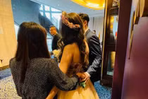 Bạn thân cô dâu nắm tay chú rể sau lưng khi cùng chụp ảnh