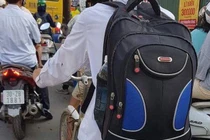 Xúc động hình ảnh nam nghèo túi to túi nhỏ, đạp xe lên phố nhập học