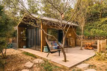 Ngôi nhà gỗ thông nằm giữa rừng núi, ánh sáng len lỏi vào tận giường ngủ