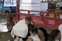 Người phụ nữ ôm con đi nhặt rau thối bên đường để sống qua ngày