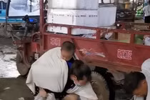 Người phụ nữ ôm con đi nhặt rau thối bên đường để sống qua ngày