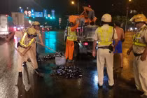 Cảnh sát giao thông TPHCM dọn vỏ bia rơi tràn trên đường giữa đêm 