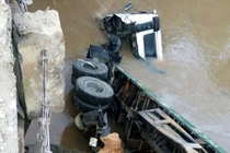 Xe đầu kéo đang chạy tông nát thành cầu rơi xuống suối