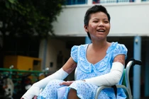 Bé gái bán vé số bị mẹ thiêu sống tươi cười xuất viện