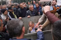 Cảnh dân khiêng quan chức y tế Ukraine ... vào thùng rác