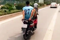 “Trẻ trâu” đầu trần lái xe máy bằng chân tại làn xe buýt BRT