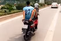 “Trẻ trâu” đầu trần lái xe máy bằng chân tại làn xe buýt BRT