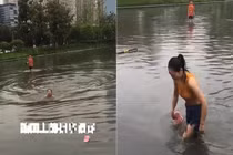 Video: Cô gái bơi qua con đường ngập nước vì sợ đi làm muộn