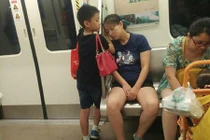 Cảm động bé trai dùng tay làm gối cho mẹ ngủ trên tàu điện