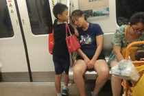 Cảm động bé trai dùng tay làm gối cho mẹ ngủ trên tàu điện