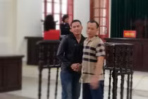 Hai bị cáo bắt tay vui mừng vì cùng được giảm án