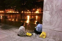 Vợ mang cơm đến cho chồng làm bảo vệ trong đêm ở Sài Gòn