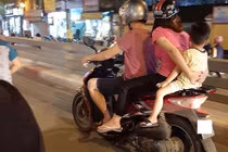 Cha mẹ để con ngồi sau cùng trên xe máy, đầu không đội mũ bảo hiểm