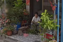 Cô gái bật khóc khi thấy mẹ đã mất ngồi trước ngôi nhà cũ