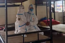 Hình ảnh em bé 2 tuổi mặc đồ bảo hộ kín mít trong khu cách ly