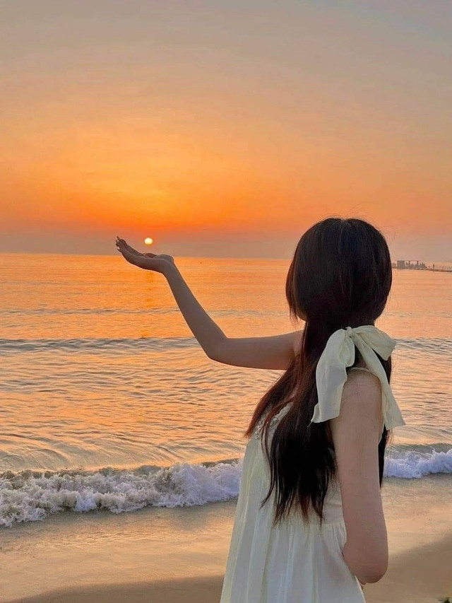 Tư thế “nâng mặt trời” là một trong những kiểu tạo dáng được ưa chuộng khi chụp ảnh hoàng hôn, mang lại cảm giác vừa thơ mộng vừa sáng tạo nơi bãi biển. Ảnh Thichchupanh hoang-hon1.jpg