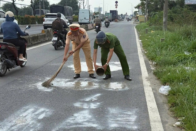Lực lượng CSGT phối hợp xóa bỏ dòng chữ. Ảnh: CA Lực lượng CSGT phối hợp xóa bỏ dòng chữ. Ảnh: CA