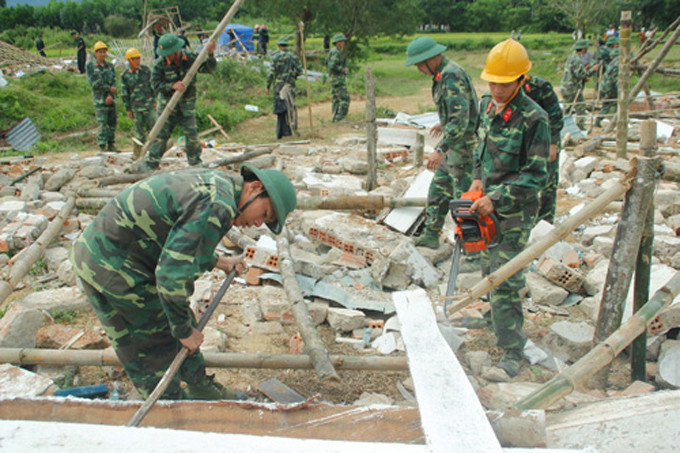 Bộ đội công binh dùng cưa máy để dọn dẹp đống đổ nát.