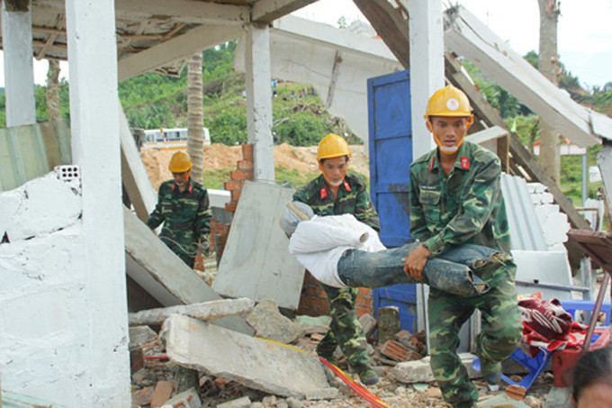 Đưa các thi thể người chết ra khỏi một căn nhà bị sập.