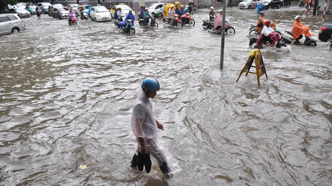 Xách giày... tìm lối đi, tại ngã tư Hai Bà Trưng - Hàng Bài (Hà Nội). Ảnh: Tuổi Trẻ