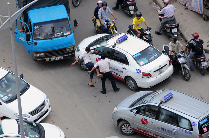 Đầu tiên tài xế xe tải đạp gãy kính chiếu hậu bên phải của xe taxi, sau đó lao vào đánh tài xế taxi.