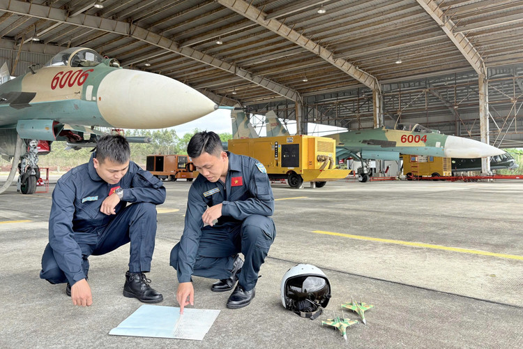 Đại úy Nguyễn Hoàng Hải Quang (phải) hội ý hiệp đồng với đồng đội trước mỗi chuyến bay. Ảnh: NVCC. z7052861540594-6b8aad6d23200166073a53c1b1ed03fa.jpg