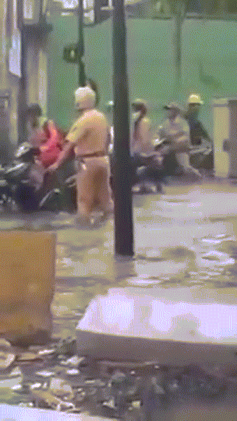 Thấy có xe di chuyển khó khăn, chiến sĩ CSGT nhanh chân chạy tới đẩy giúp.