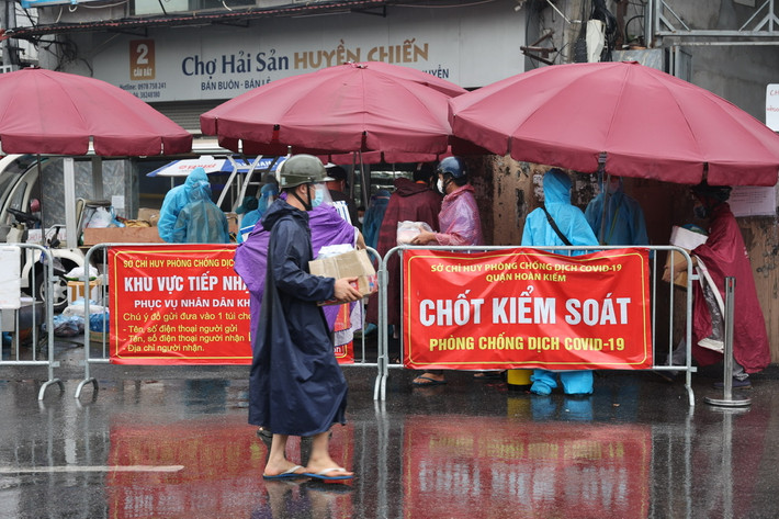 Sáng nay (15/8), mặc dù trời mưa nhưng nhiều người vẫn xếp hàng chờ gửi đồ vào bên trong khu vực cách ly.
