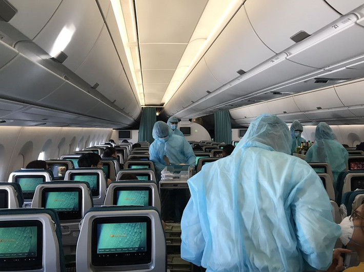 Các tiếp viên mặc trang phục bảo hộ phục vụ hành khách trong suốt 12-13 giờ bay. (Ảnh: VNA cung cấp).
