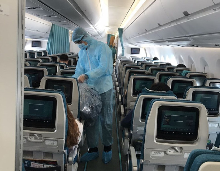 Các tiếp viên mặc trang phục bảo hộ phục vụ hành khách trong suốt 12-13 giờ bay. (Ảnh: VNA cung cấp).