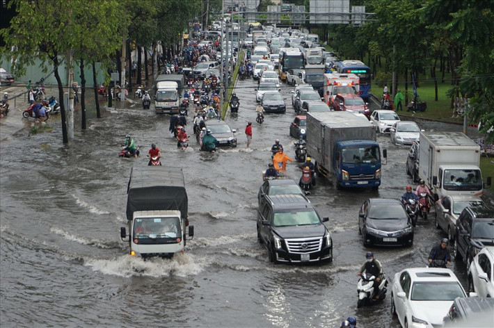 Cơn mưa chiều kéo dài gần 1 giờ đồng hồ khiến tuyến đường Nguyễn Hữu Cảnh (quận Bình Thạnh) bị ngập sâu trong nước, các phương tiện di chuyển qua khu vực gặp nhiều khó khăn.