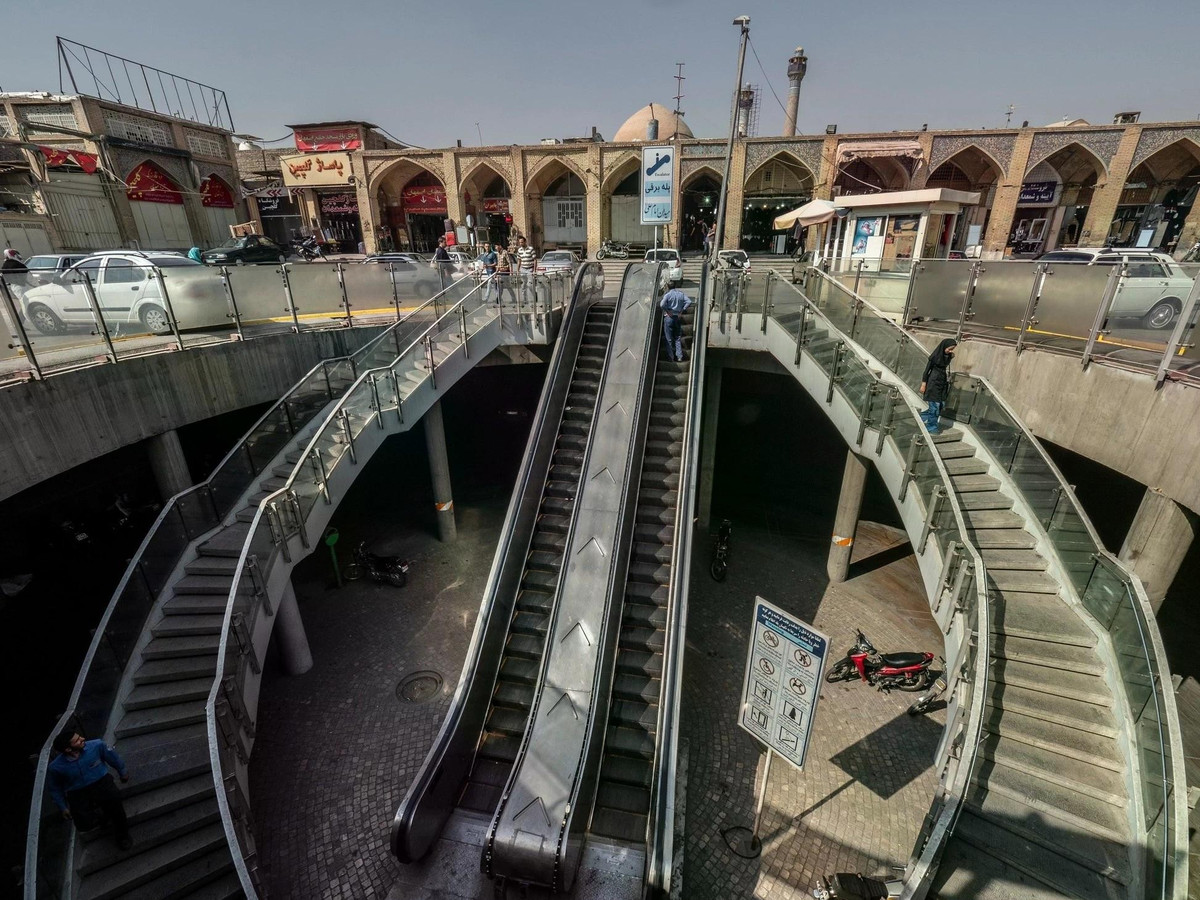 Khung cảnh lối đi bộ và thang cuốn xuống hầm, phía sau là khu chợ cổ Tehran Grand Bazaar, đóng vai trò quan trọng trong đời sống kinh tế, văn hóa và xã hội của Iran. Đây không chỉ là nơi mua sắm sầm uất mà còn là một điểm đến lịch sử, giúp du khách hiểu rõ hơn về thương mại và phong cách sống của người dân thủ đô Tehran. Tại đây có bán mọi thứ, nổi bật là vải vóc và thảm Ba Tư dệt tay tinh xảo, nổi tiếng thế giới; trang sức vàng và bạc; gia vị và trà Iran, thảo mộc và trà Ba Tư; trang phục truyền thống đến hiện đại.