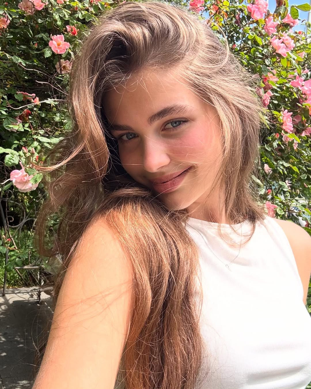 Varvara ăn mặc đơn giản, chọn lối trang điểm mỏng nhẹ như không, chụp ảnh bên cạnh giàn hoa hồng. Ảnh: Instagram Varvara Yakovenko.