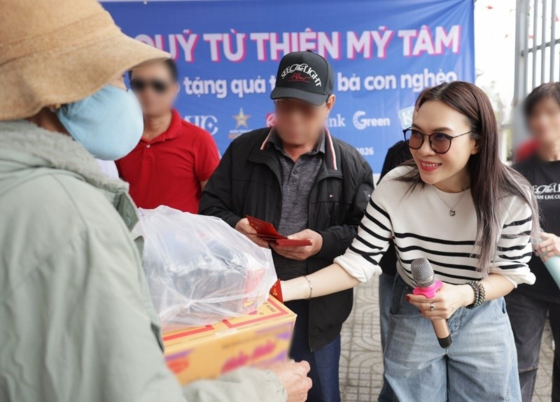 Trong chương trình, Mỹ Tâm xuất hiện với phong cách giản dị. Nữ ca sĩ diện áo len kẻ sọc đen – trắng phối cùng quần jeans xanh và giày thể thao, tạo hình ảnh gần gũi, năng động. Cô để tóc thẳng tự nhiên và liên tục nở nụ cười khi trò chuyện, trao quà cho bà con. Ảnh: FB Mỹ Tâm.