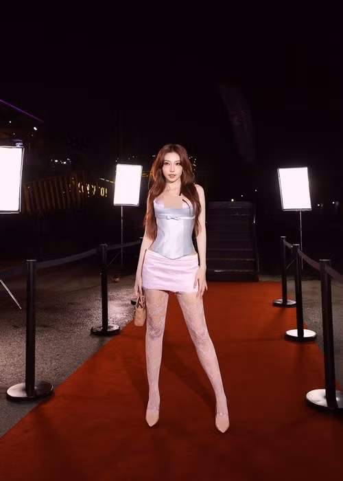 Tại một sự kiện thảm đỏ, nữ ca sĩ diện váy mini kết hợp tất ren và giày cao gót, thu hút sự chú ý với phong thái tự tin.