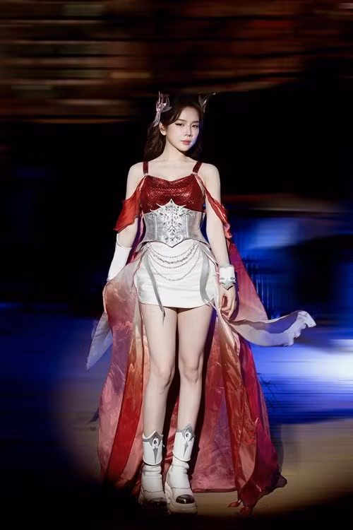 Bên cạnh phong cách đời thường, Mie còn gây chú ý khi xuất hiện trên sân khấu với trang phục mang cảm hứng fantasy. Trong một chương trình, nữ DJ diện bộ đồ tông đỏ – bạc với corset kim loại, chân váy ngắn cùng lớp áo choàng mỏng phía sau, tạo hiệu ứng chuyển động khi cô bước đi. Phụ kiện cài tóc hình sừng nhỏ kết hợp boots cao cổ giúp tổng thể thêm phần cá tính, đậm chất biểu diễn.