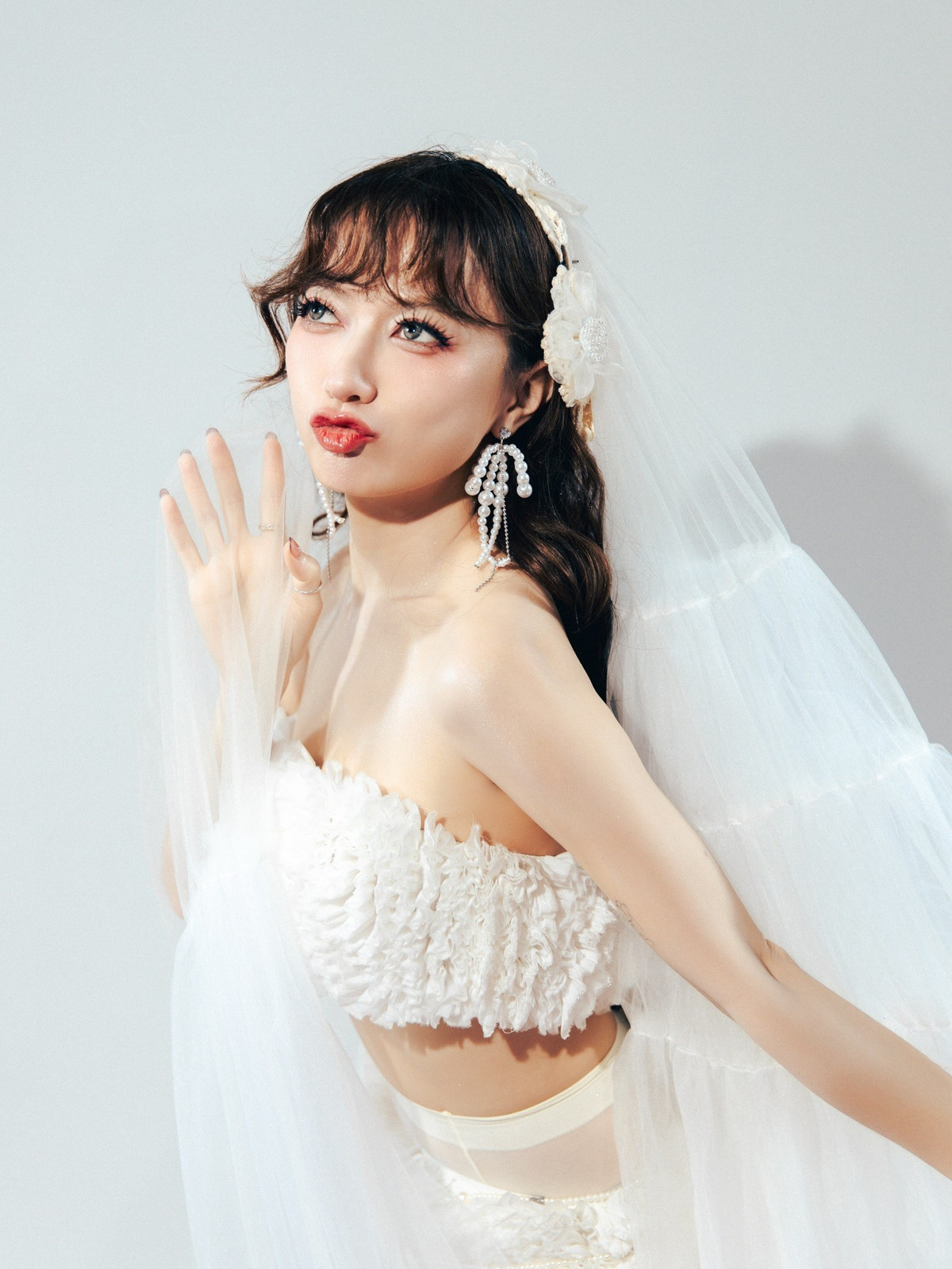 Trong bộ ảnh, Xuân Nghi chọn thiết kế cô dâu phá cách với áo cúp ngực chất liệu xếp tầng, chân váy ngắn phối voan dài quét sàn.