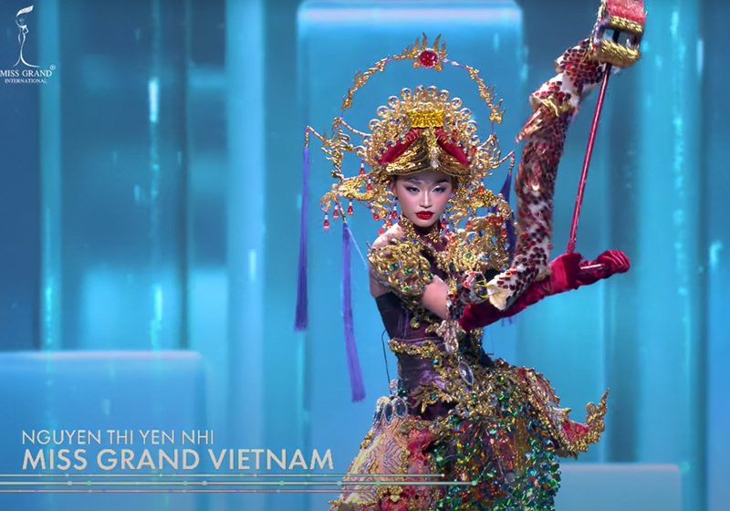 Trang phục Thăng Long Hội có trọng lượng khoảng 30kg. Trước khán giả quốc tế, Yến Nhi sải bước tự tin. Trước phần thi, Yến Nhi gần như phải tự mình lắp ráp và mặc trang phục. Ảnh: Sen Vàng.