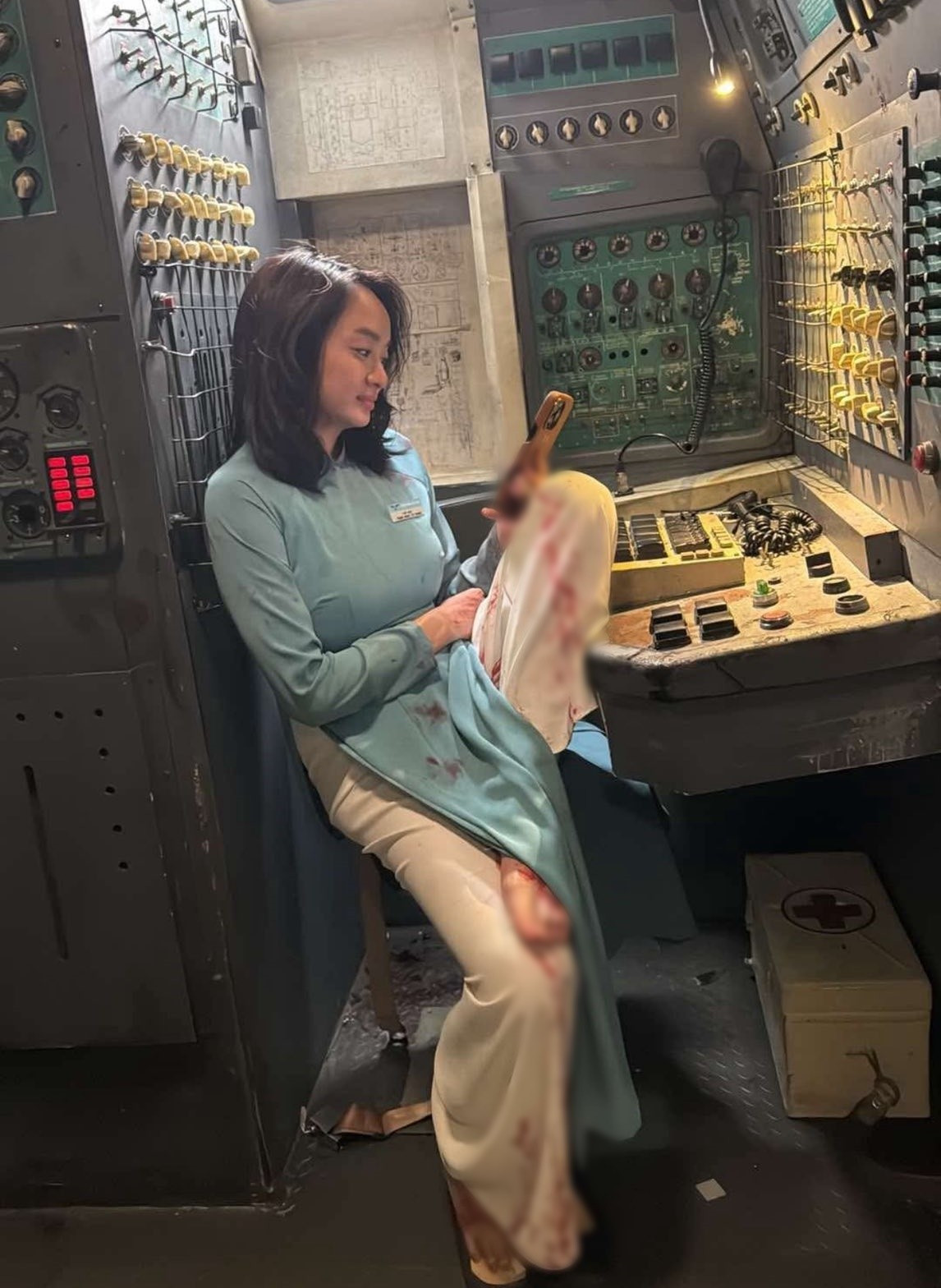 Trong lúc nghỉ ngơi giữa các cảnh quay trong phim Tử chiến trên không, Kaity Nguyễn sử dụng điện thoại. Ảnh: FB Kaity Nguyễn.