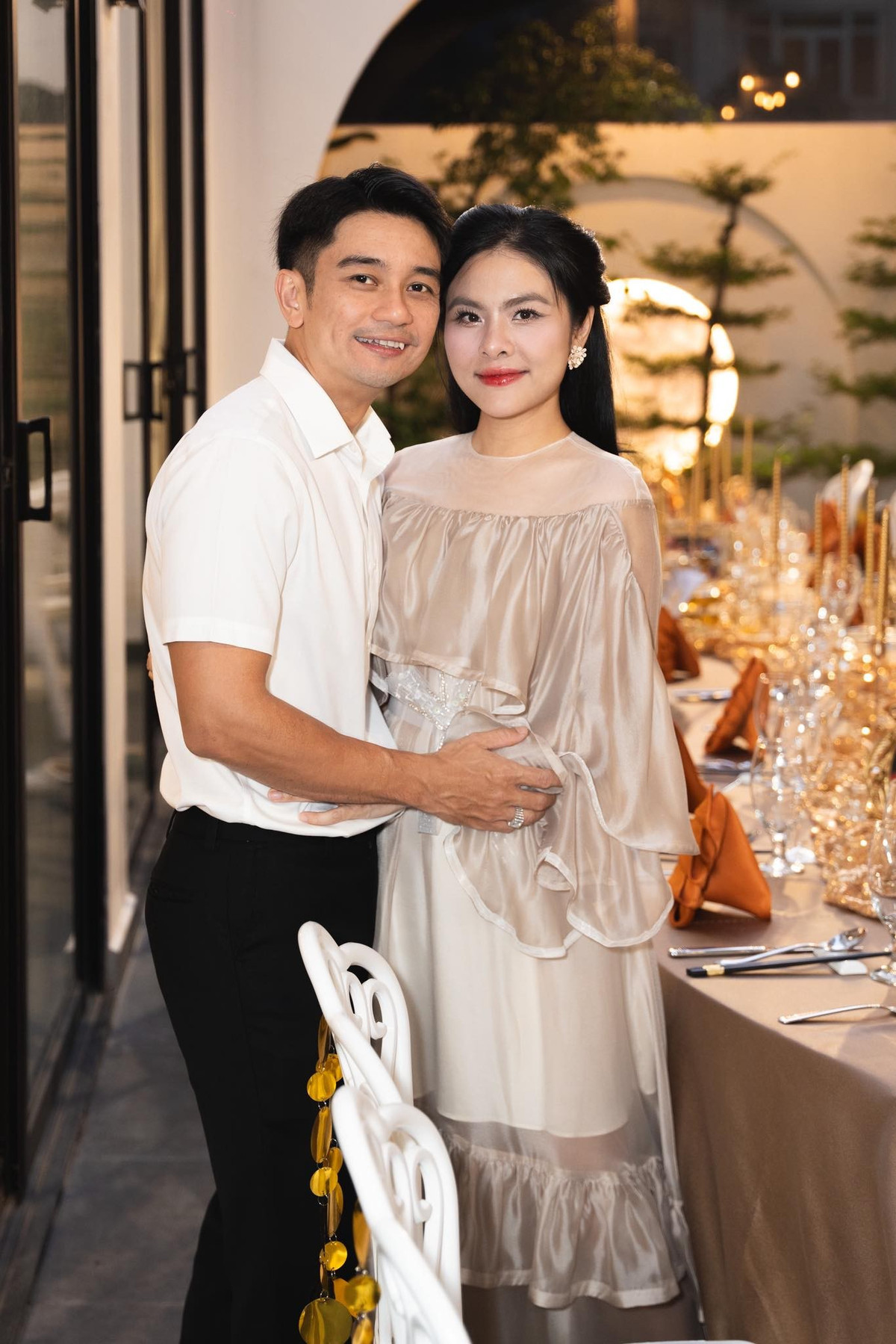 Vân Trang diện váy màu be nhạt, trang điểm nhẹ nhàng, Quân Lê mặc áo sơ mi trắng, quần tối màu. Cặp đôi dành cho nhau nhiều cử chỉ tình tứ.